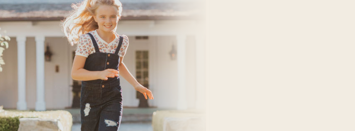 Girl running in Foxtale overalls and floral tee