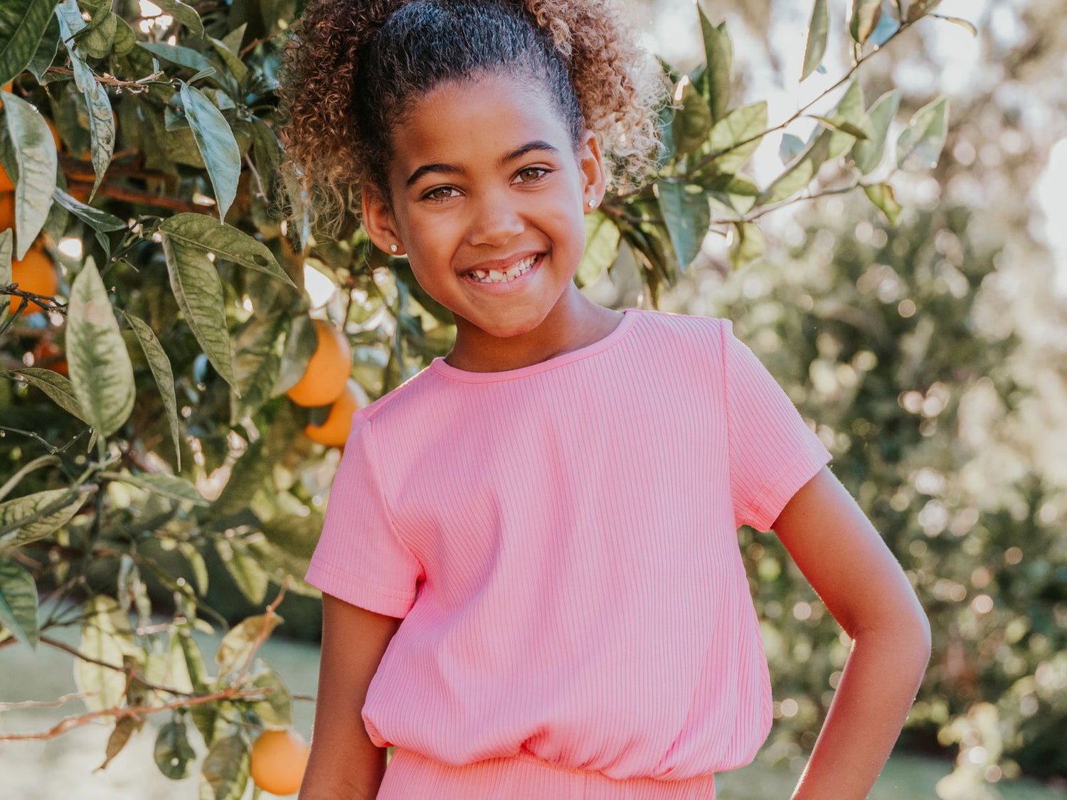 Tween in Finding Foxtale's Lucy Top in front of orange tree