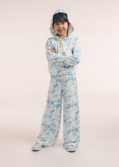 Tween girl wearing a blue-and-white tie-dye zip-up hoodie and matching pants, hood up