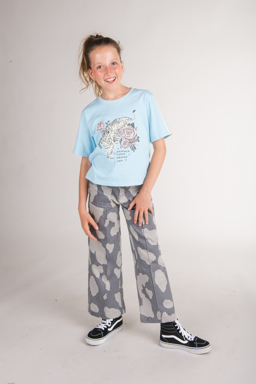 Tween girl wearing grey camo-print cargo bottoms with a light blue tiger graphic tee