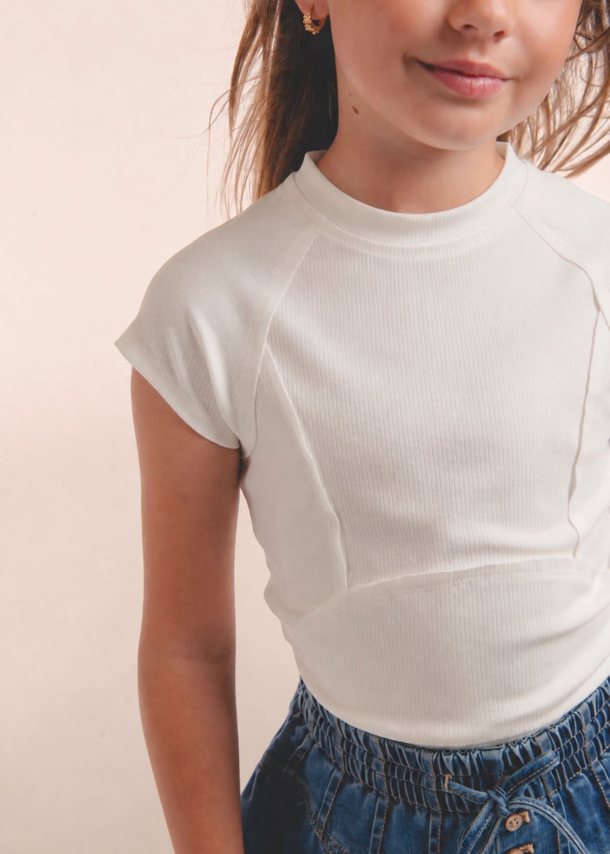Close-up of tween girl wearing white cap-sleeve top with tie-dye sash at waist