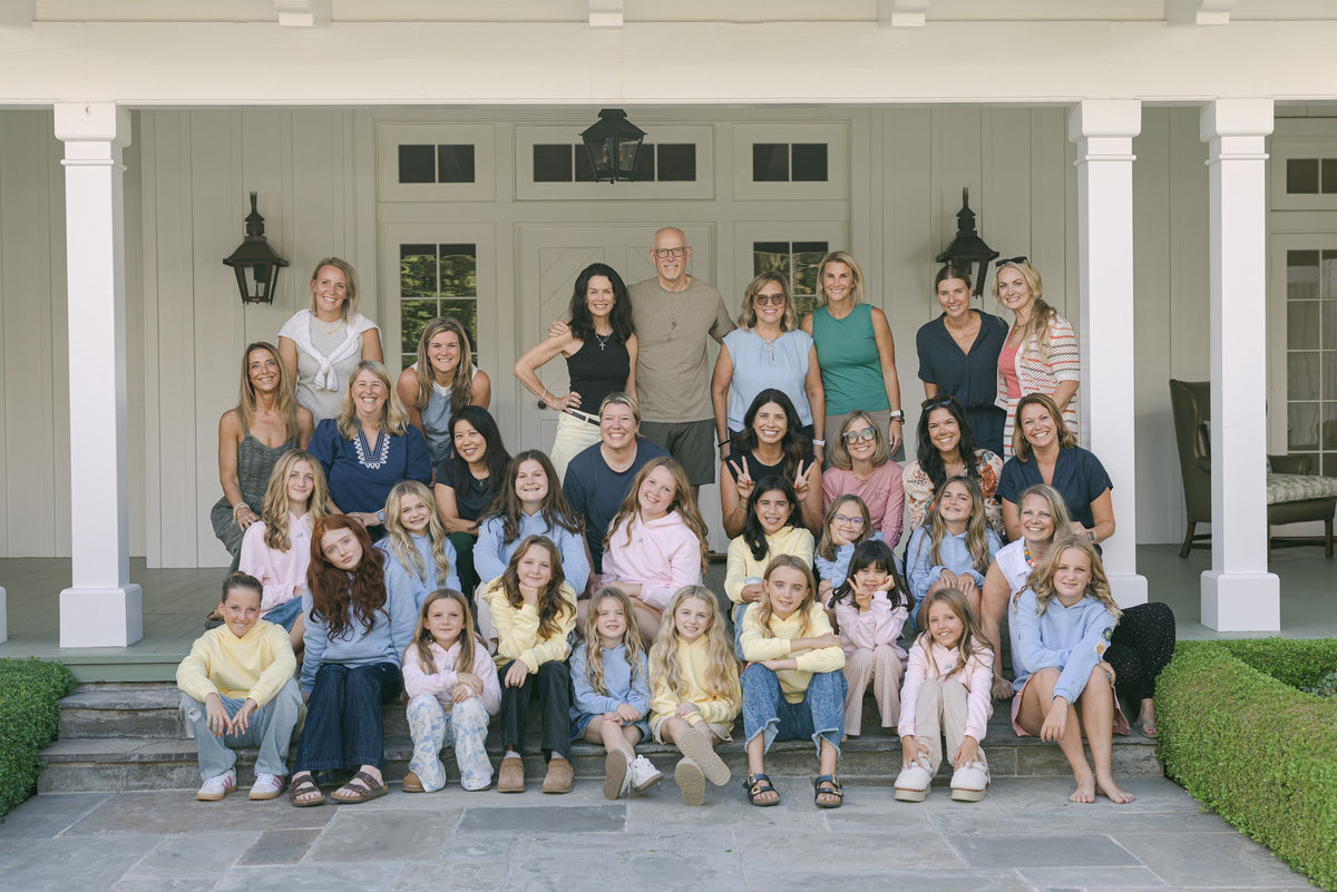 Moms and daughters gathered on a porch for an IMPRINT group photo
