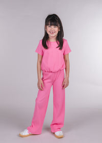 Tween girl wearing pink ribbed Lucy pants with a matching short-sleeve bubble-hem top